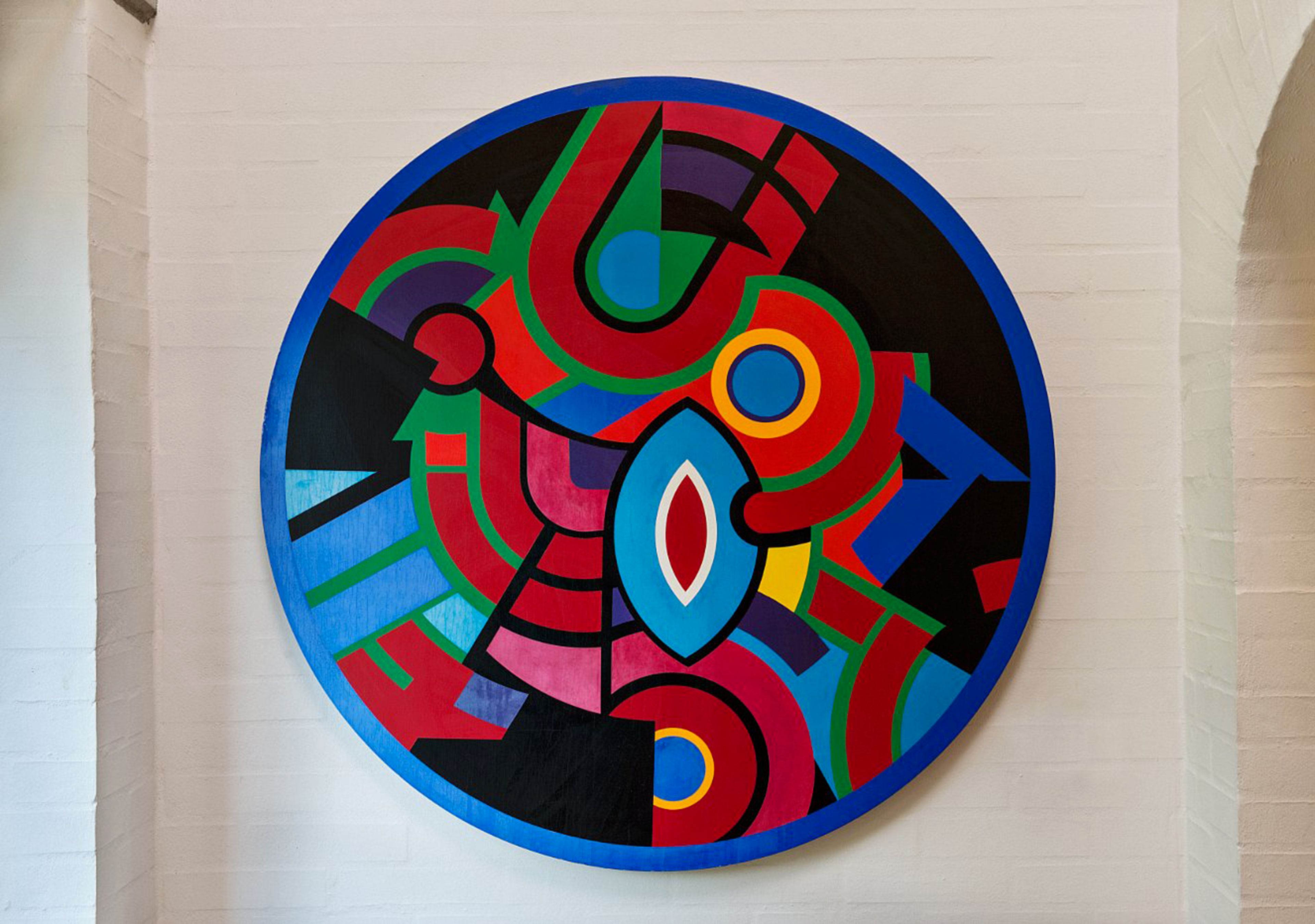 A circular abstract art piece on a wall.
