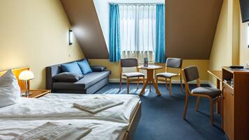 Een hotelkamer met een bed, een bank, een bureau en een stoel.
