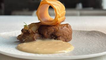 Un plato con carne y salsa.