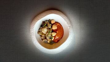 A bowl of food with nuts and seeds on a textured surface.