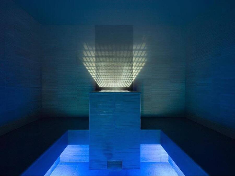 A room with a central light fixture and a rectangular platform.