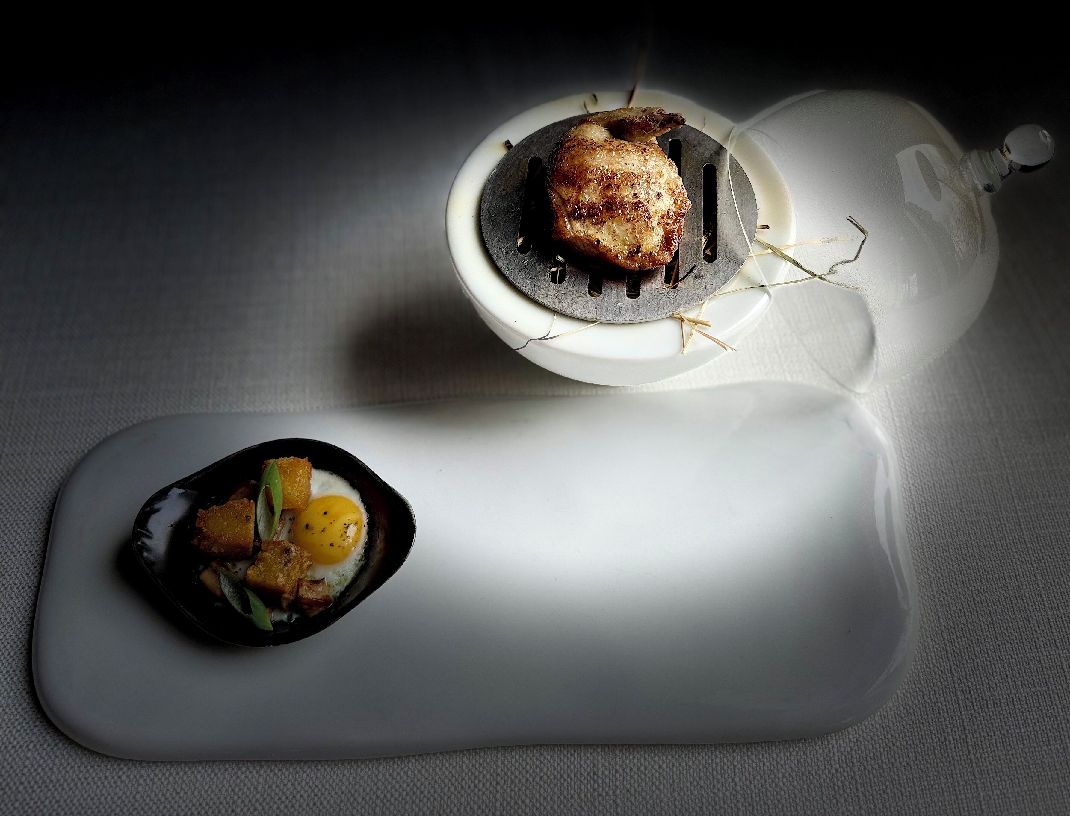 A dining table with a plate of food and a bottle.