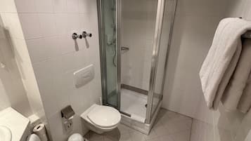 Un baño moderno con ducha de vidrio, inodoro y lavabo.