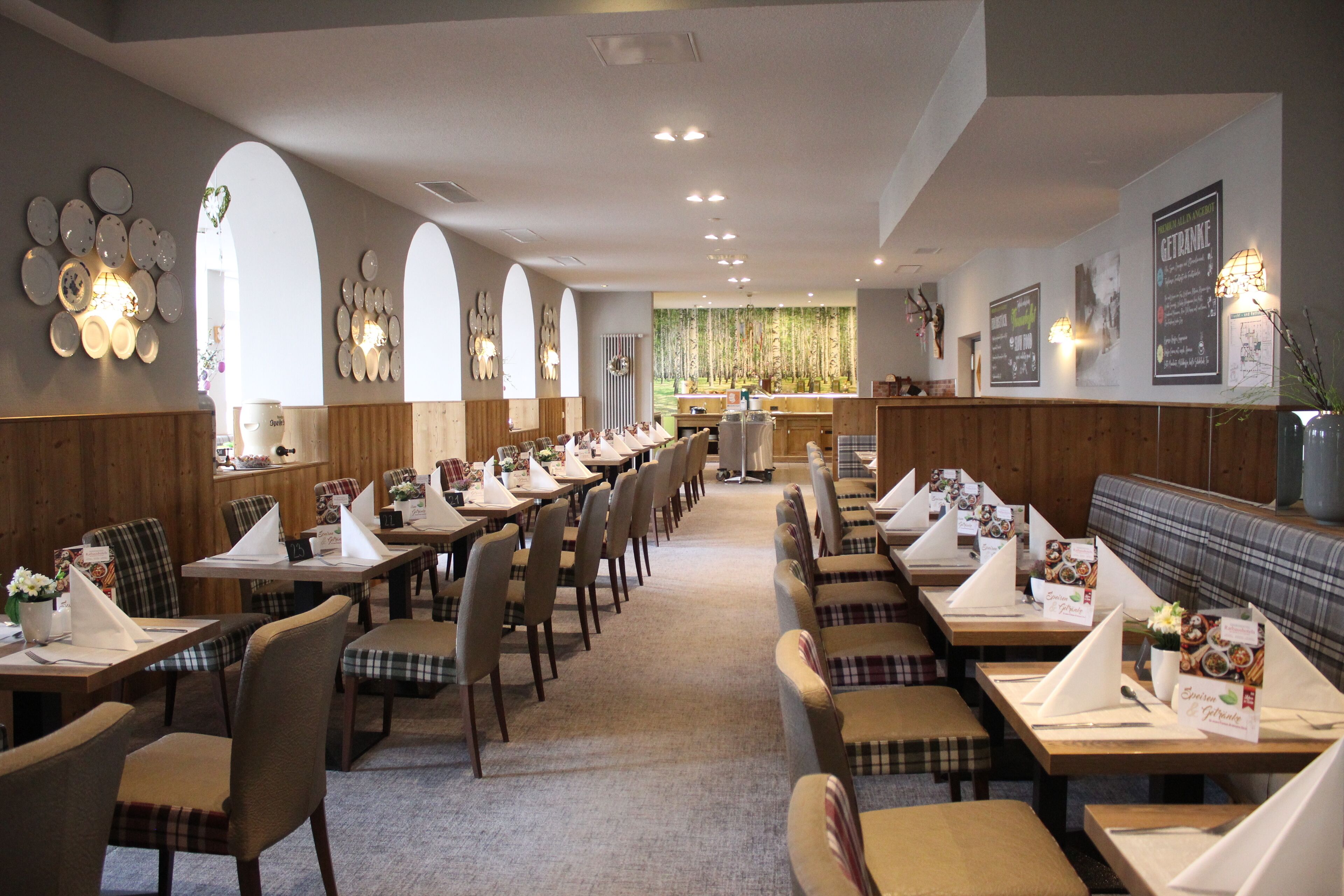Un restaurante con mesas largas comunitarias, cabinas individuales y una zona de bar.