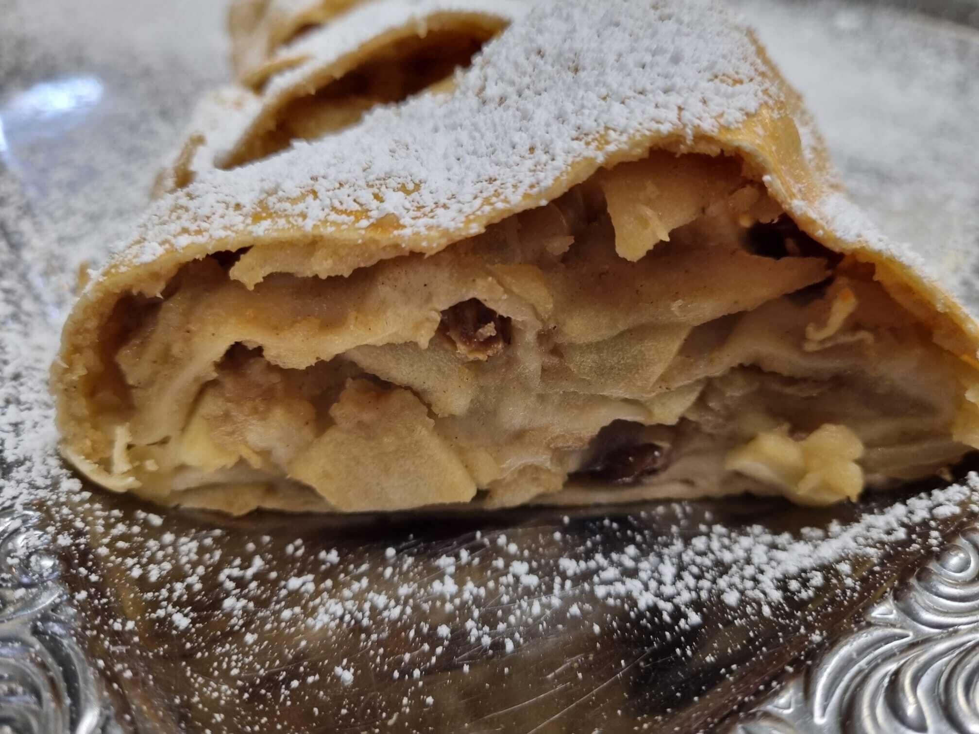 A dessert with a powdered topping, likely a pastry or cake, on a decorative plate.