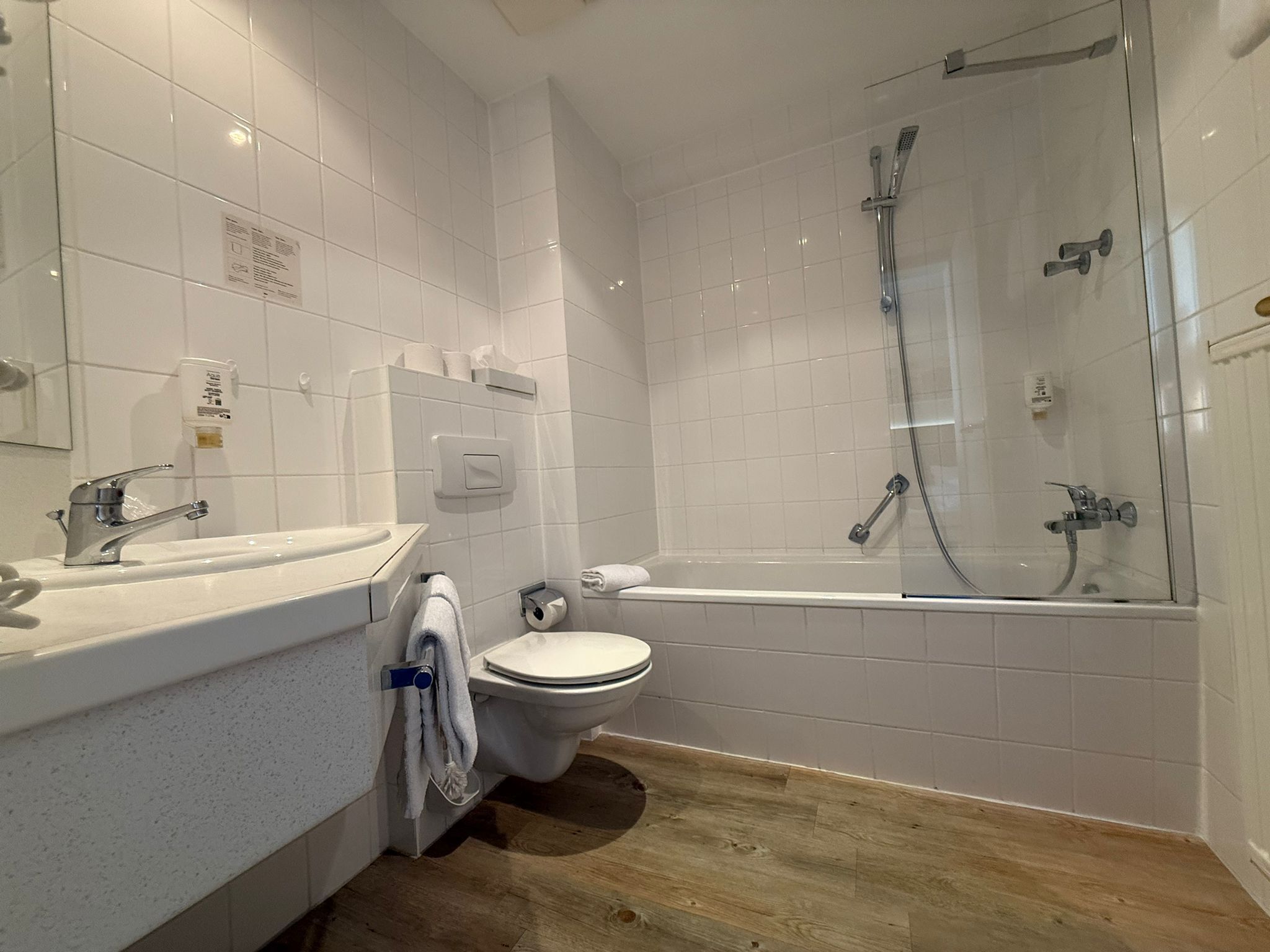 Een moderne badkamer met toilet, wastafel en douchecabine.