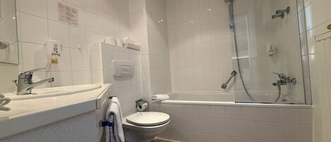 A modern bathroom with a toilet, sink, and glass-enclosed shower.