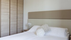 A bedroom with a bed, a nightstand, and a wardrobe. - Eden Park Resort (San Giuliano Terme)