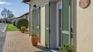 A building with green shutters, a reception sign, and a paved walkway with potted plants. - Eden Park Resort (San Giuliano Terme)