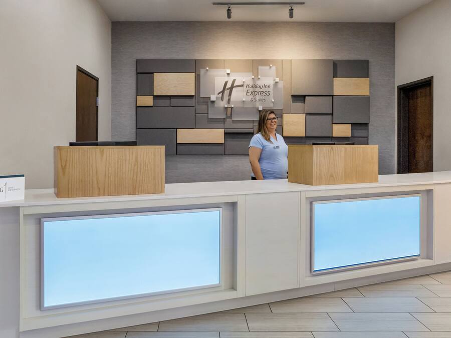 Uma receção com design moderno, com a placa da Holiday Inn Express & Suites e um ecrã digital.