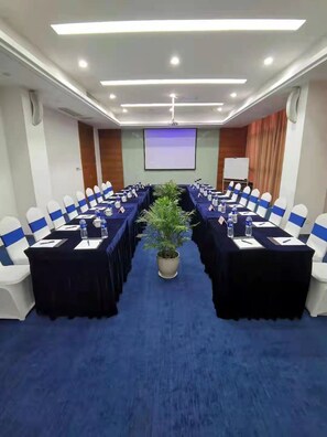 A conference room with a long table, blue chairs, and a potted plant. - Holiday Inn Express Suzhou Changjiang by IHG (Suzhou)