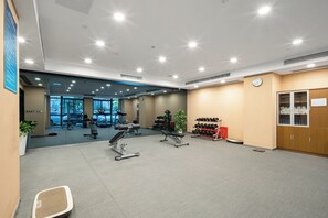 A gym with exercise equipment, a clock, and a water dispenser. - Holiday Inn Express Suzhou Changjiang by IHG (Suzhou)