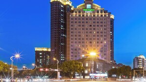 A multi-story hotel with a prominent 'Holiday Inn Express' sign, surrounded by urban infrastructure.