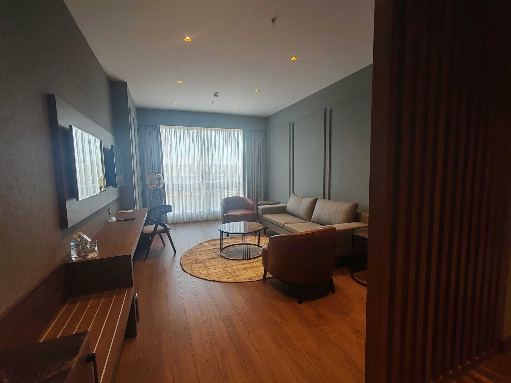 Una sala de estar moderna con un sofá, sillones, una mesa de centro y un comedor.