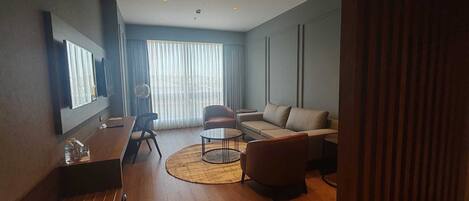 Una sala de estar moderna con un sofá, sillones, una mesa de centro y un comedor.