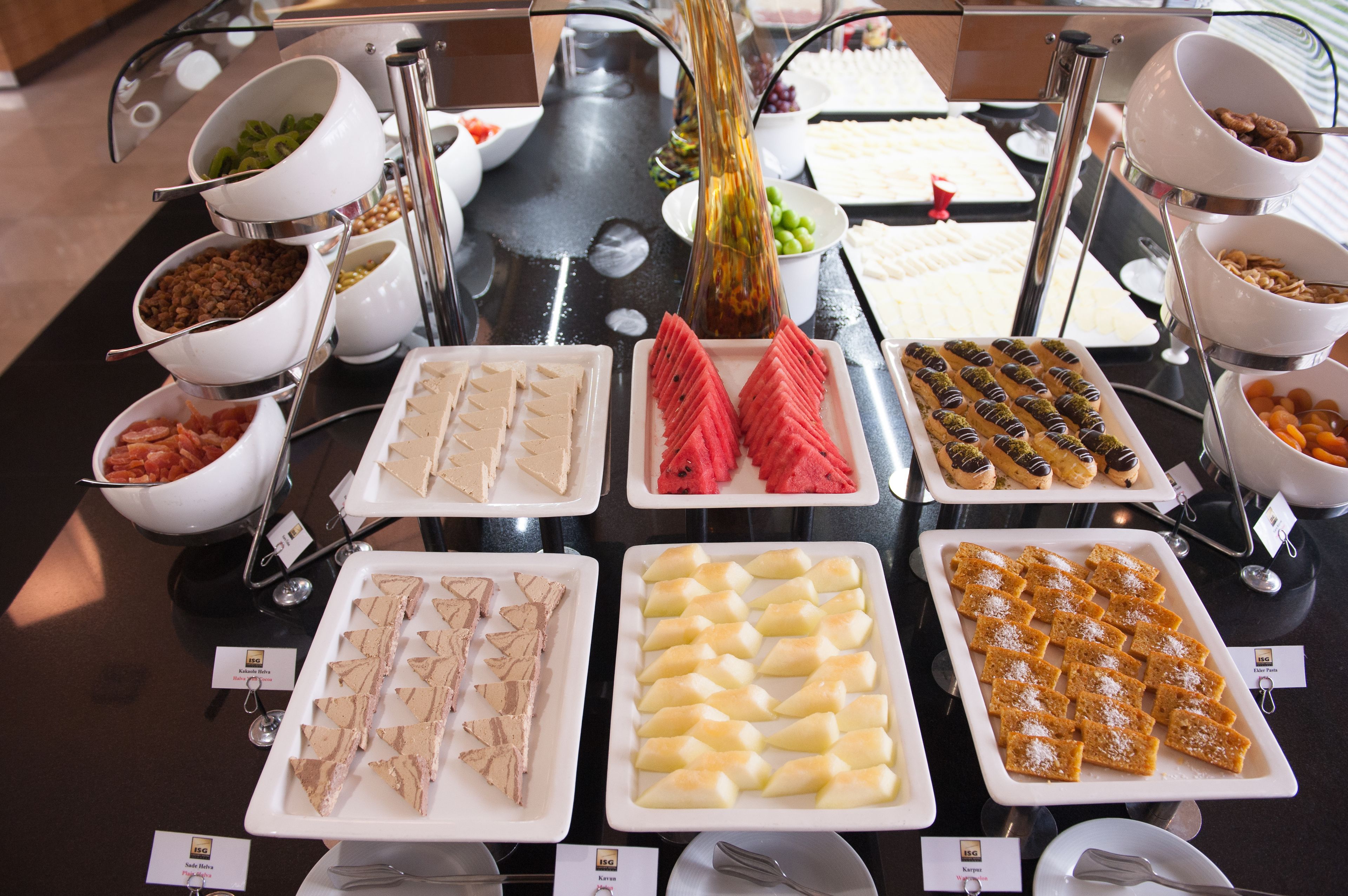 A buffet with various food items including salads, fruits, and desserts.