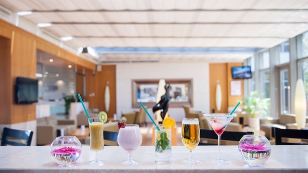 A bar area with various drinks and a television screen in the background. - ISG Sabiha Gokcen Airport Hotel - Special Class (Istanbul)
