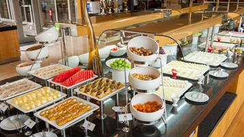 A buffet with various food items and serving utensils.