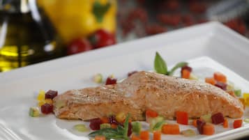 Um prato branco com salmão e legumes picados.