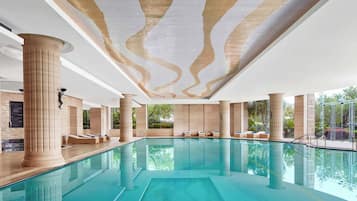 Una piscina techada, una piscina al aire libre de temporada, sombrillas