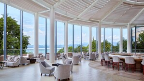 Amplia sala de estar con ventanas grandes, asientos cómodos y vistas al exterior.