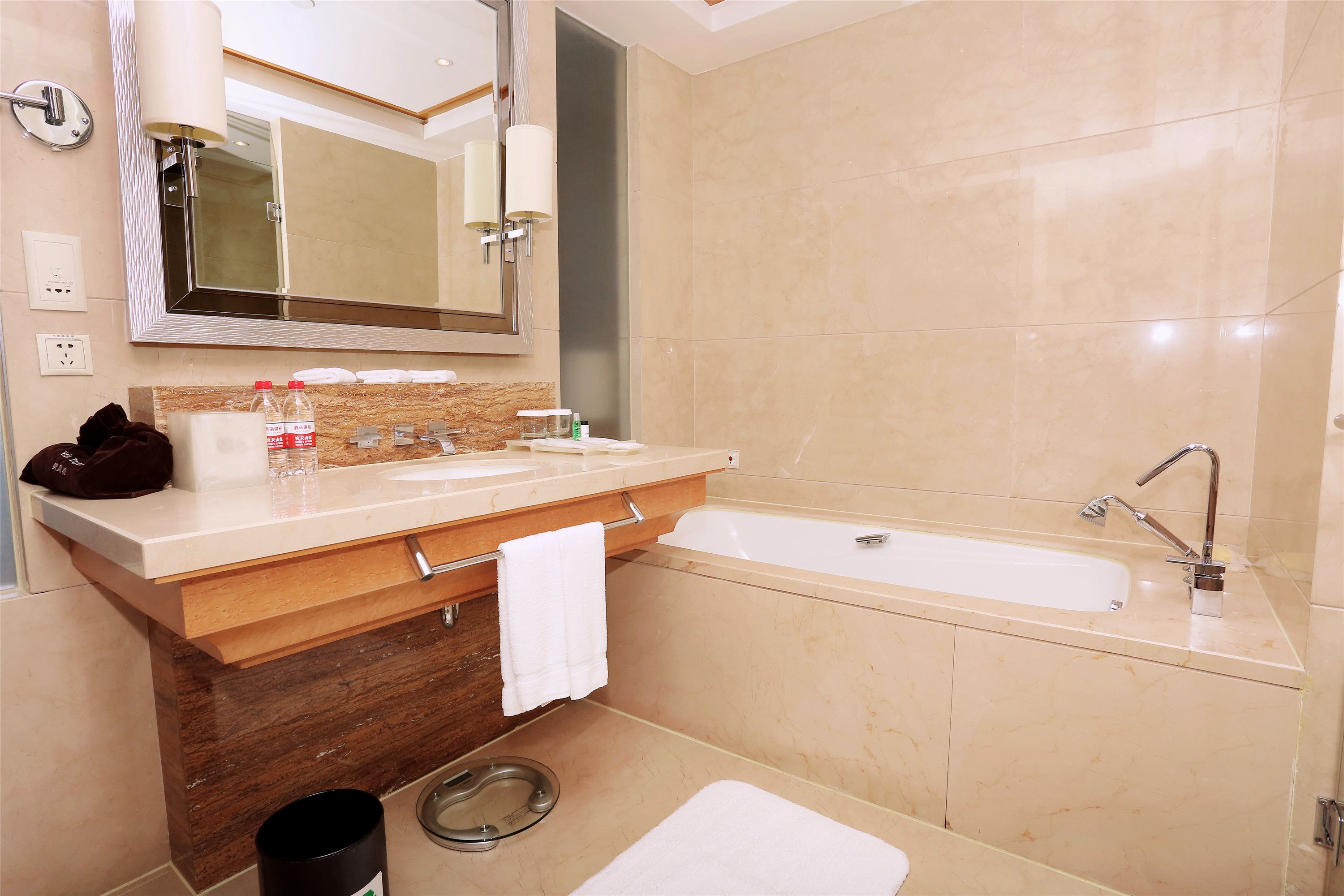Un baño moderno con un espejo grande, una bañera y un tocador con perchero.