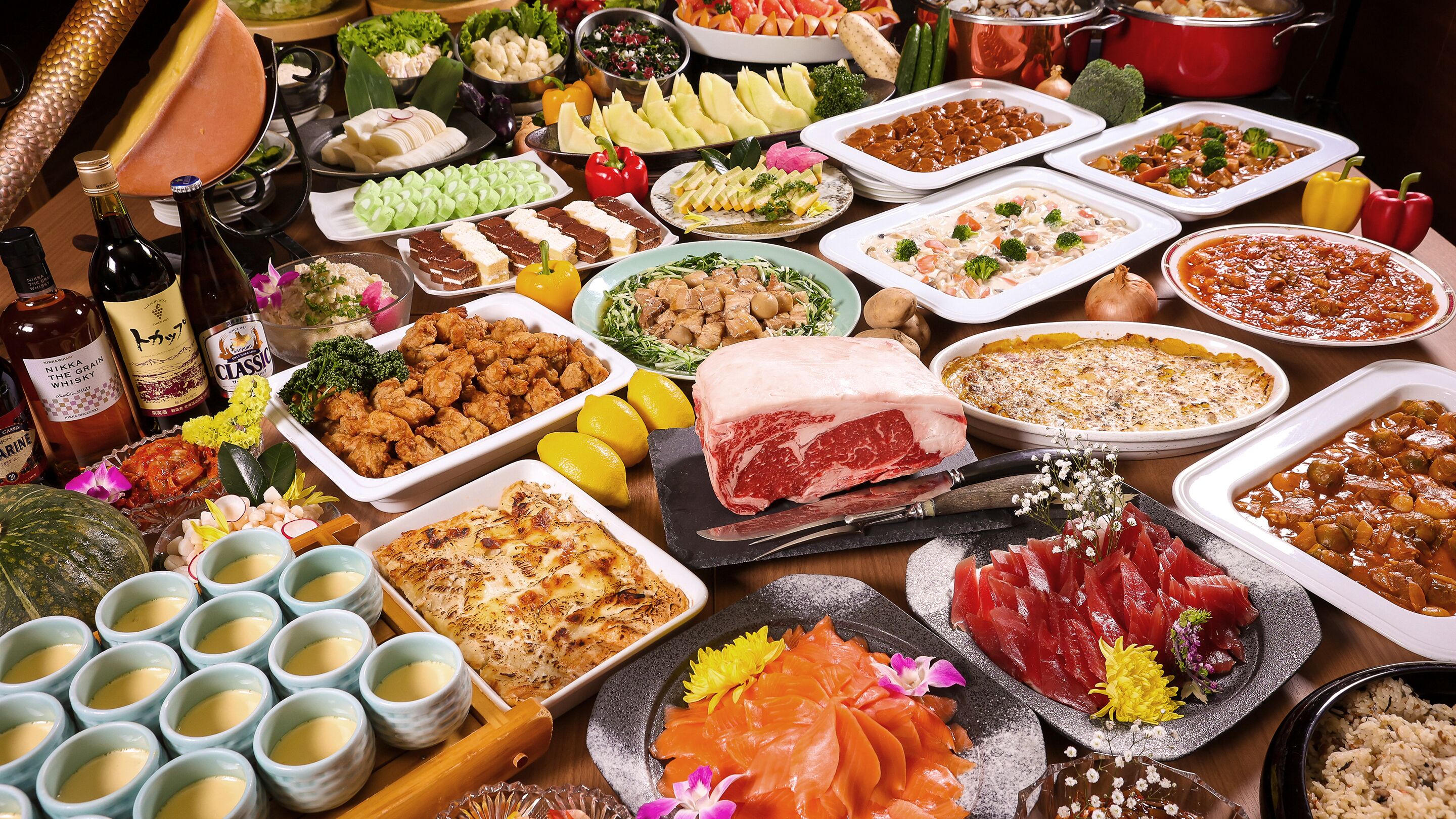 Un bufé con diversos platos, como mariscos, carnes y postres.