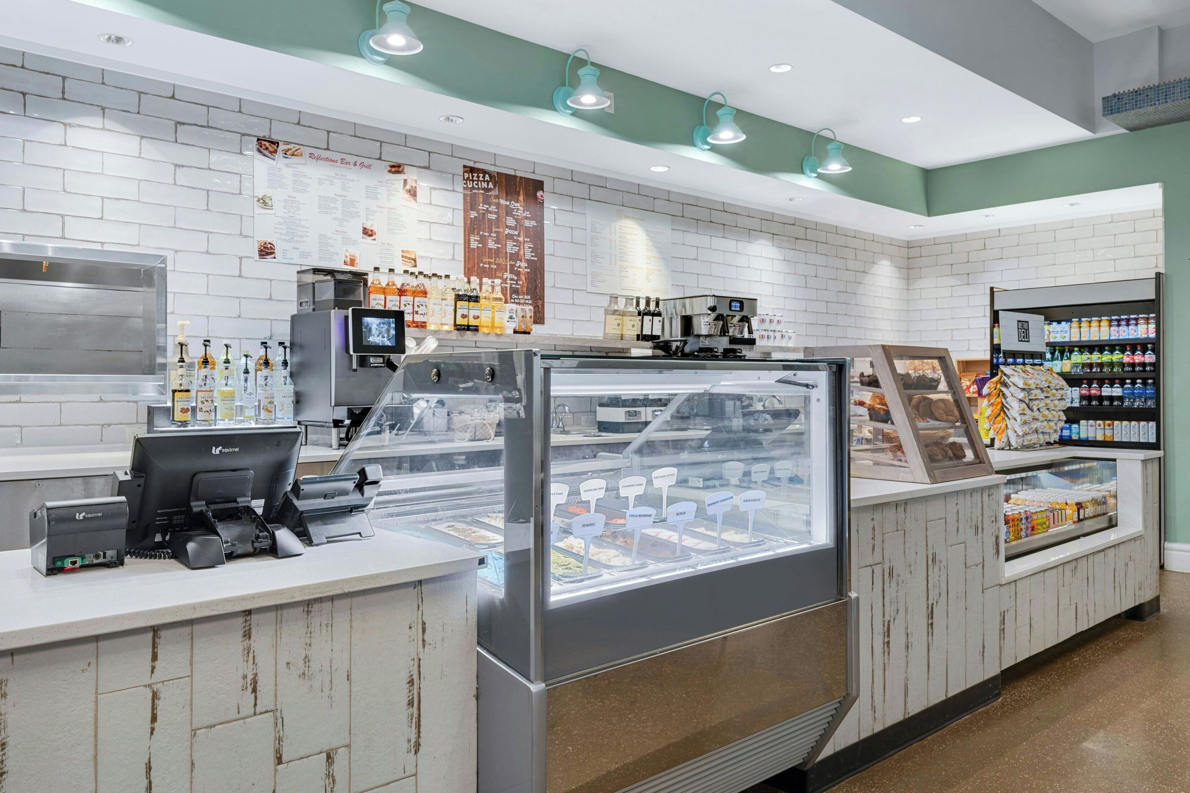 Un comptoir de boulangerie avec une vitrine, une machine à café et un réfrigérateur-vitrine.