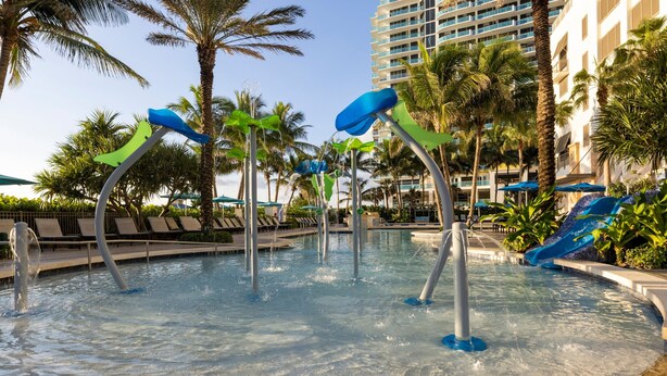 A pool area with water features and palm trees.