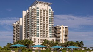 A high-rise hotel with multiple balconies and a beachside location.
