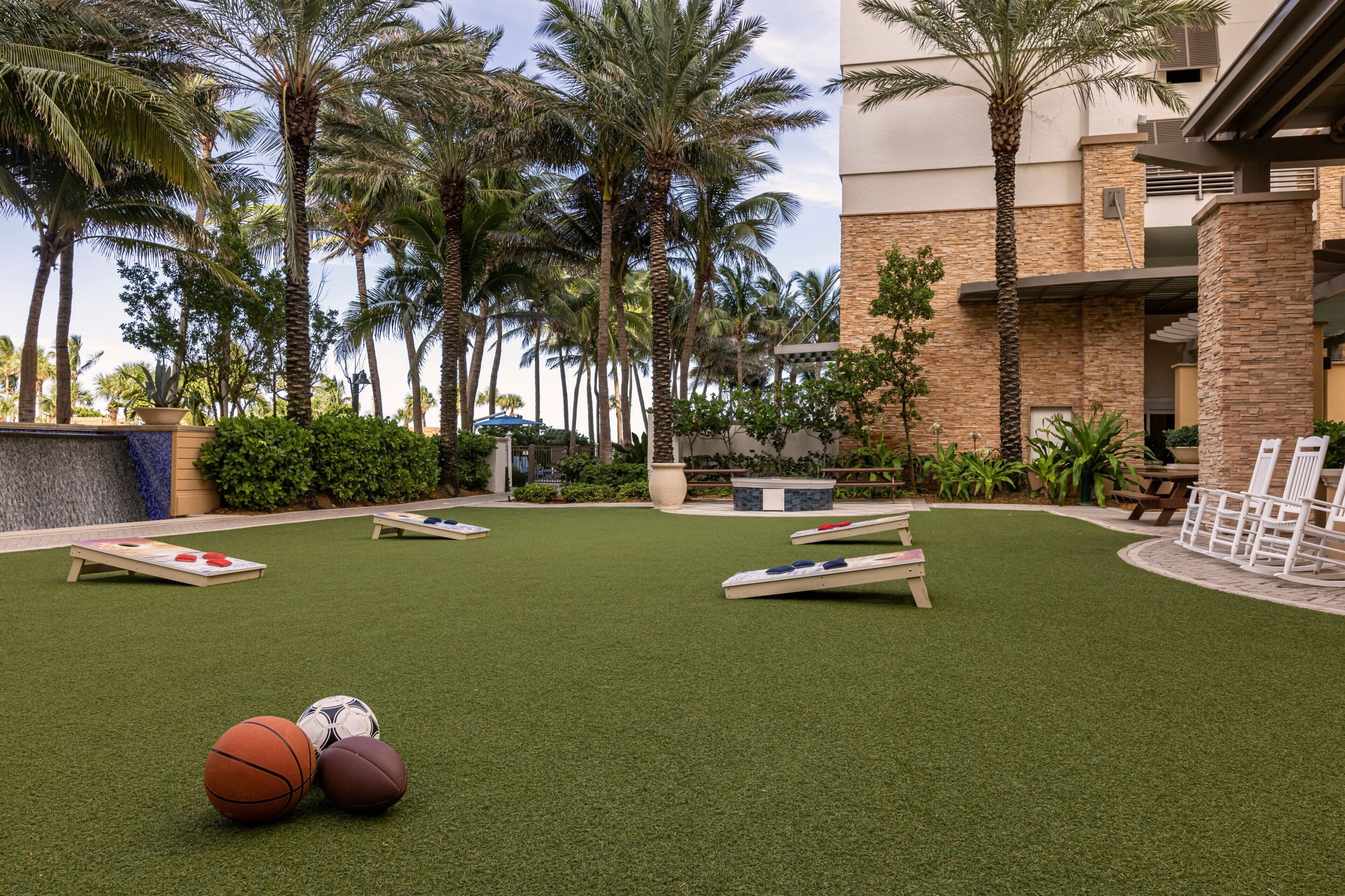 Un espace extérieur doté d’une pelouse artificielle, d’un terrain de basketball et d’une table de billard.