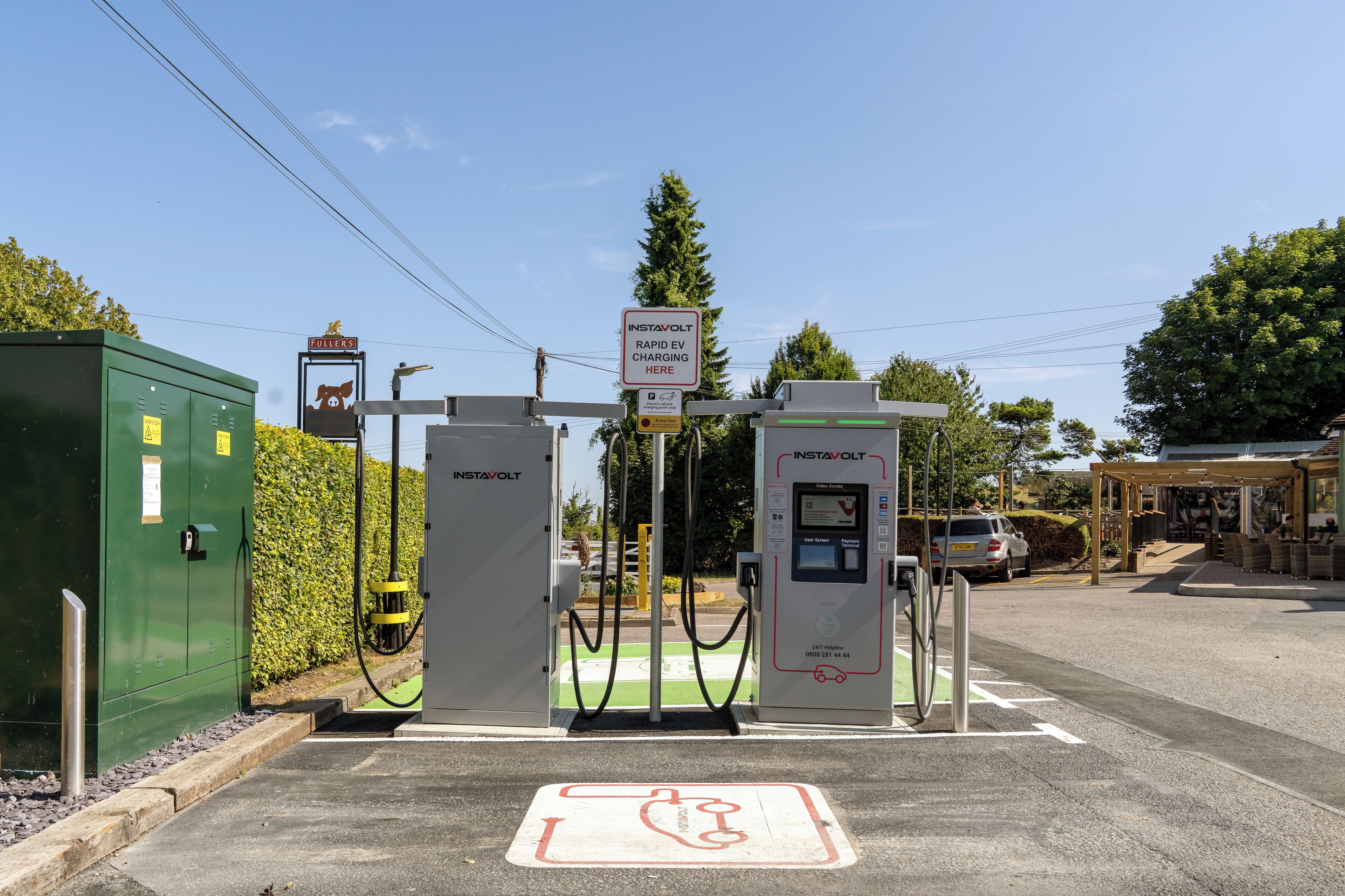 Una estación de carga rápida para vehículos eléctricos con un cartel que indica que es un servicio Instavolt.