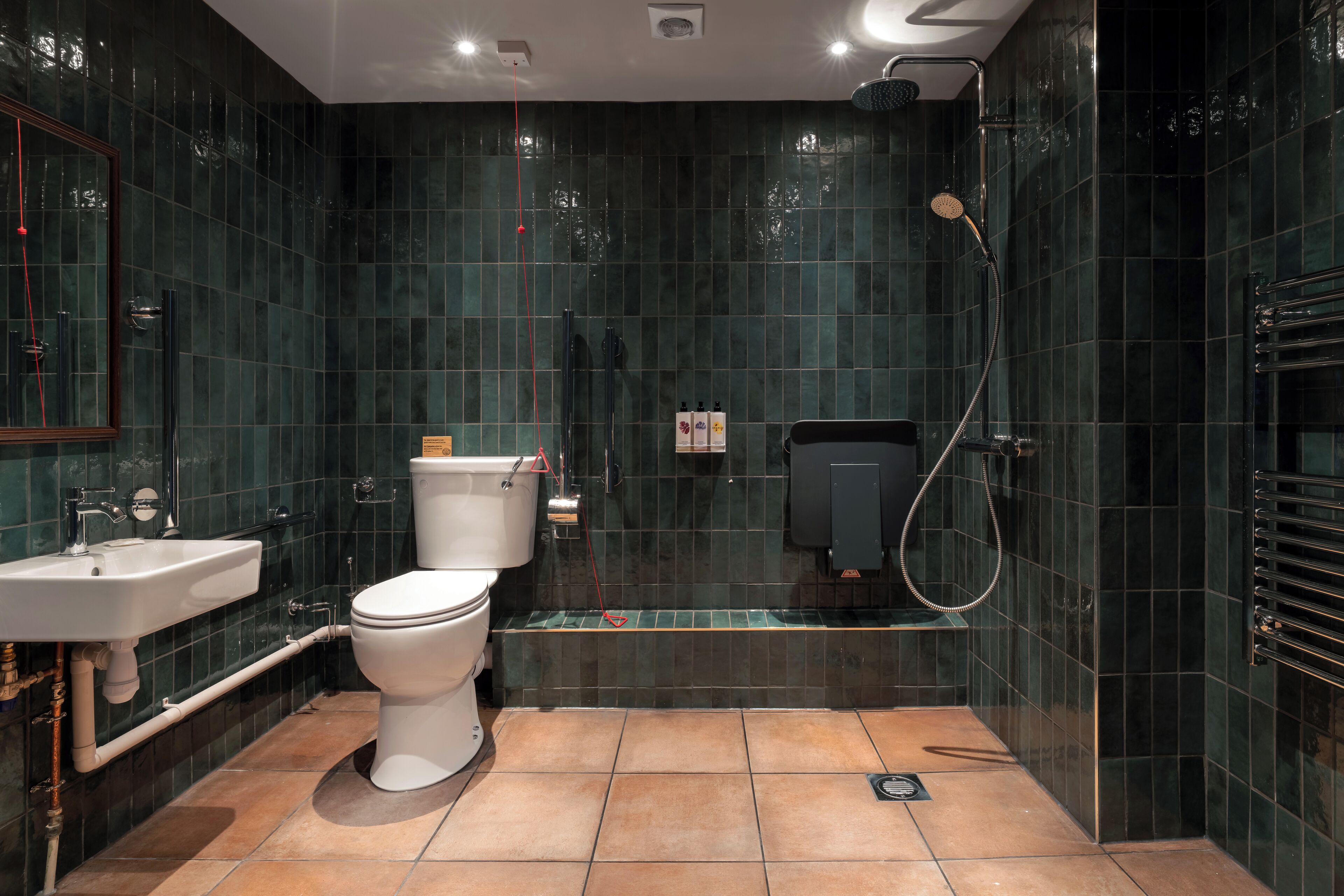 Un baño moderno con inodoro, lavamanos y zona de ducha.