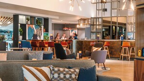 Un espace de détente moderne doté d’un bar, de sièges et de plantes décoratives.