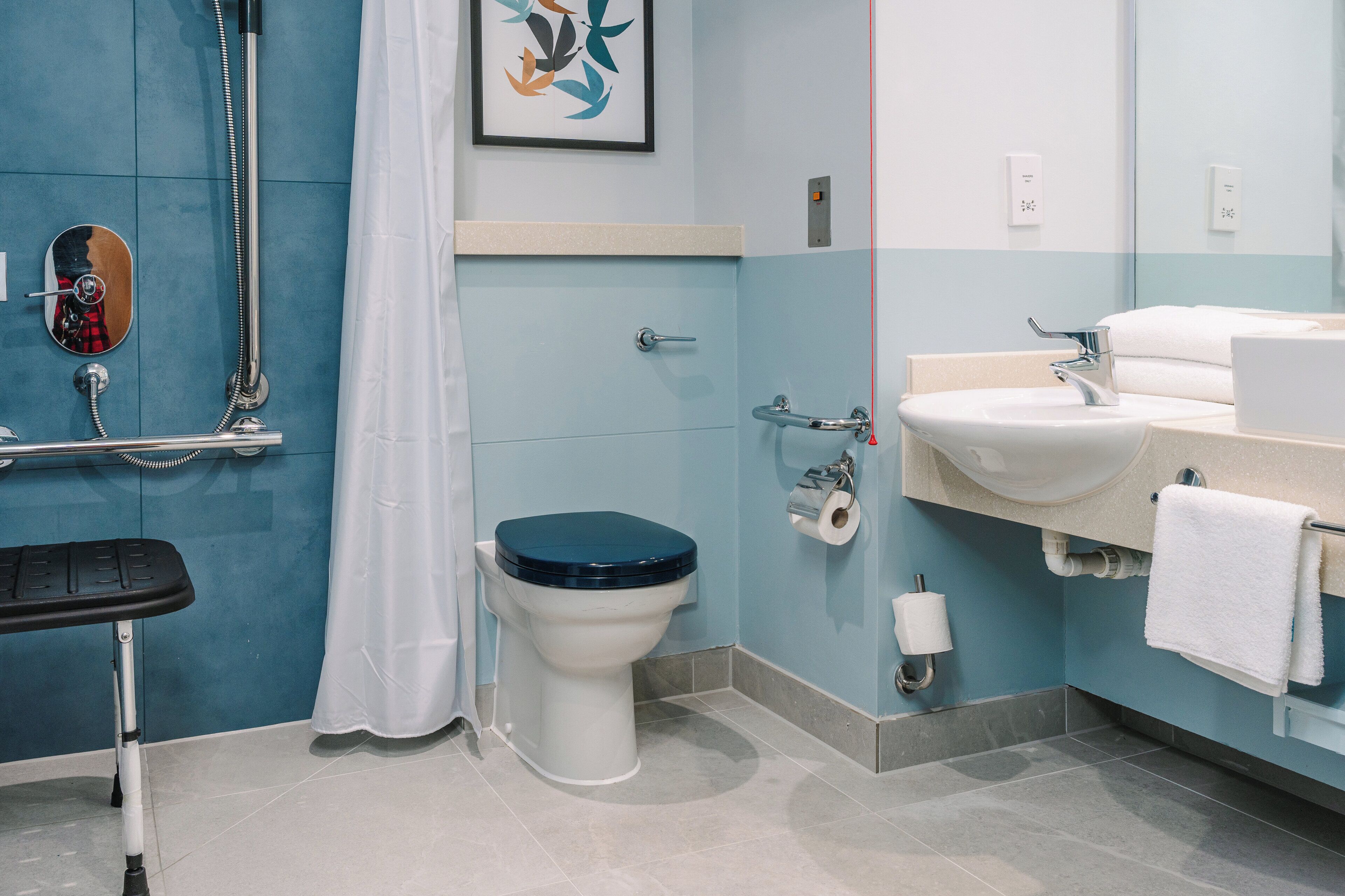 A bathroom with a toilet, shower, and sink.