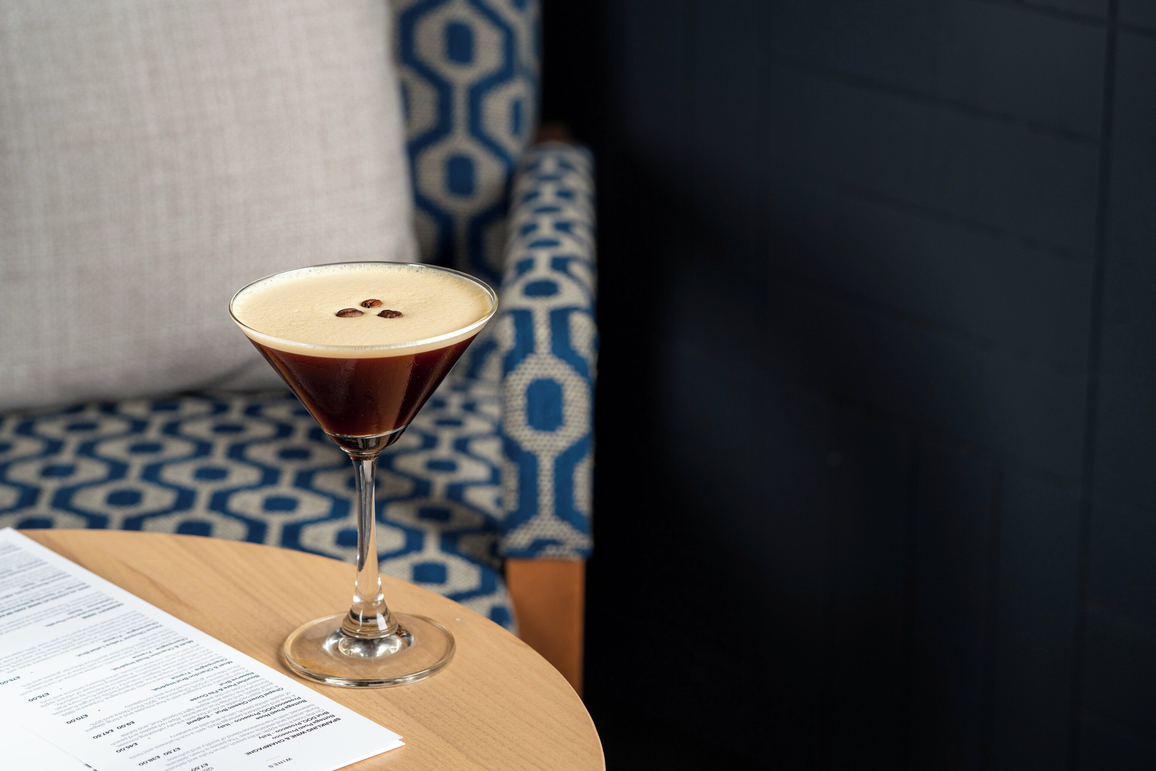 Una copa de martini con espuma sobre una mesa de madera.