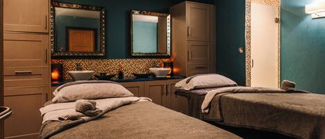 Une chambre d’hôtel avec deux lits, une salle de bain avec un miroir et un lavabo.