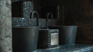 Un baño con tres lavamanos y un espejo.