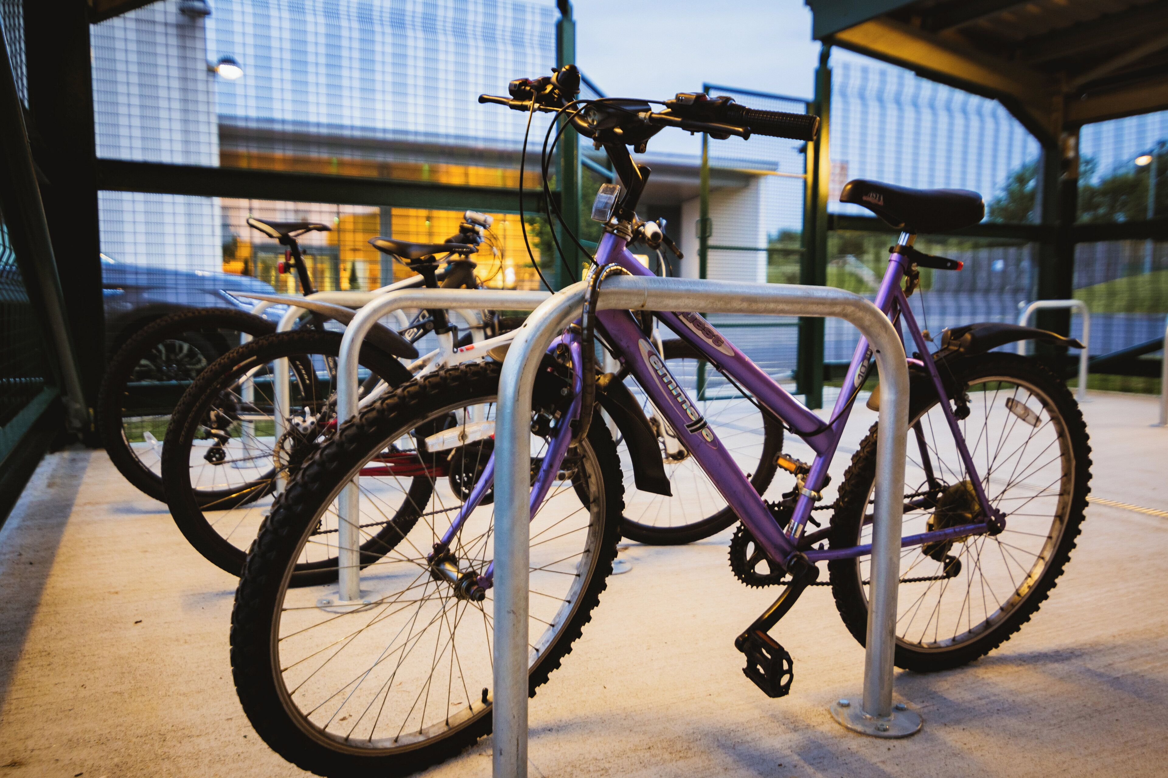 A bicycle rack with multiple bicycles parked.