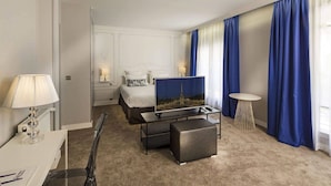 Una habitación de hotel con cama, televisión, escritorio y silla.