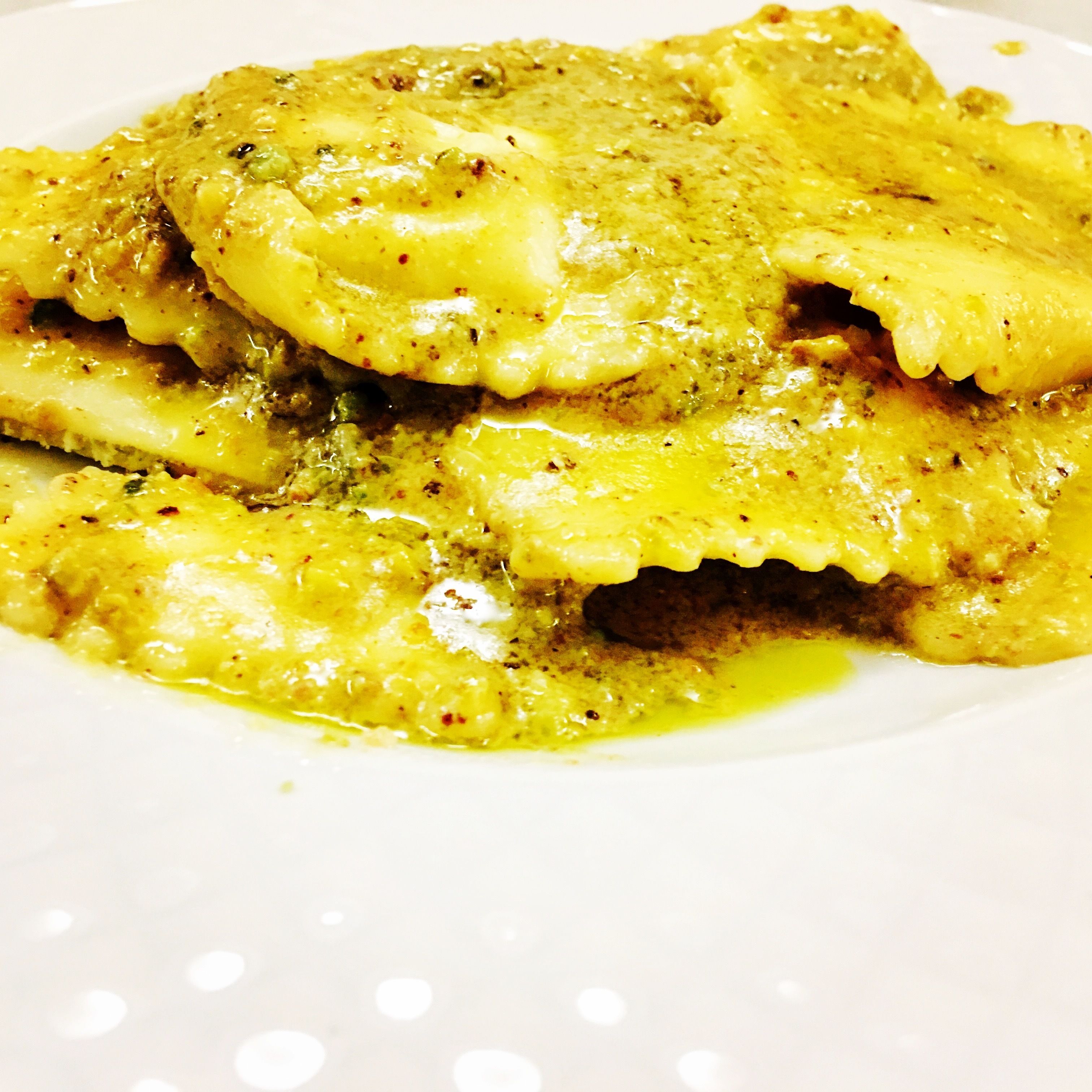 A plate of food with a yellow sauce and herbs.
