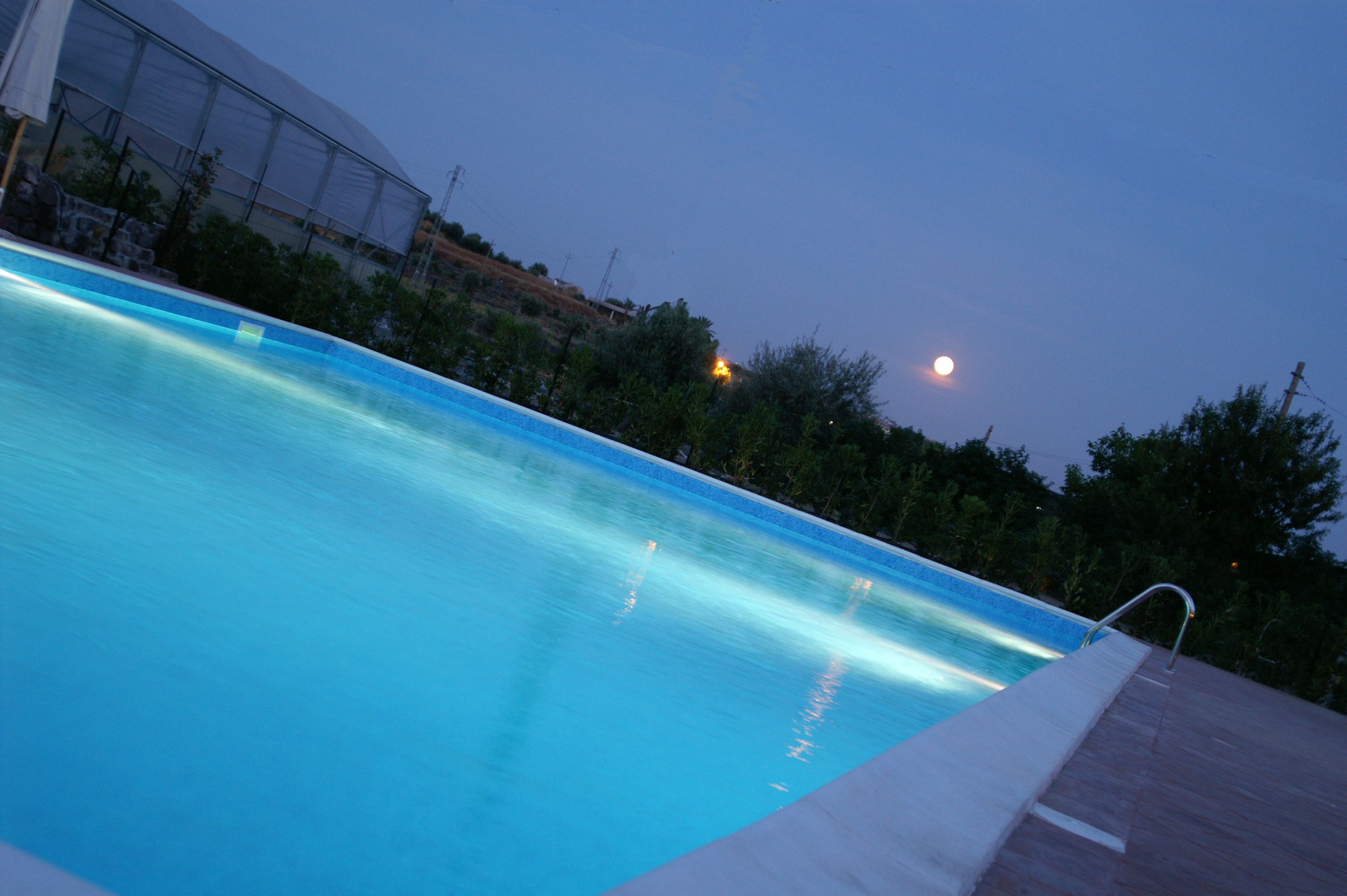 Una piscina con una vista despejada de la luna en el cielo.