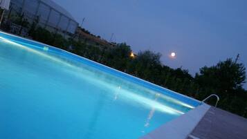 Una piscina con una vista despejada de la luna en el cielo.