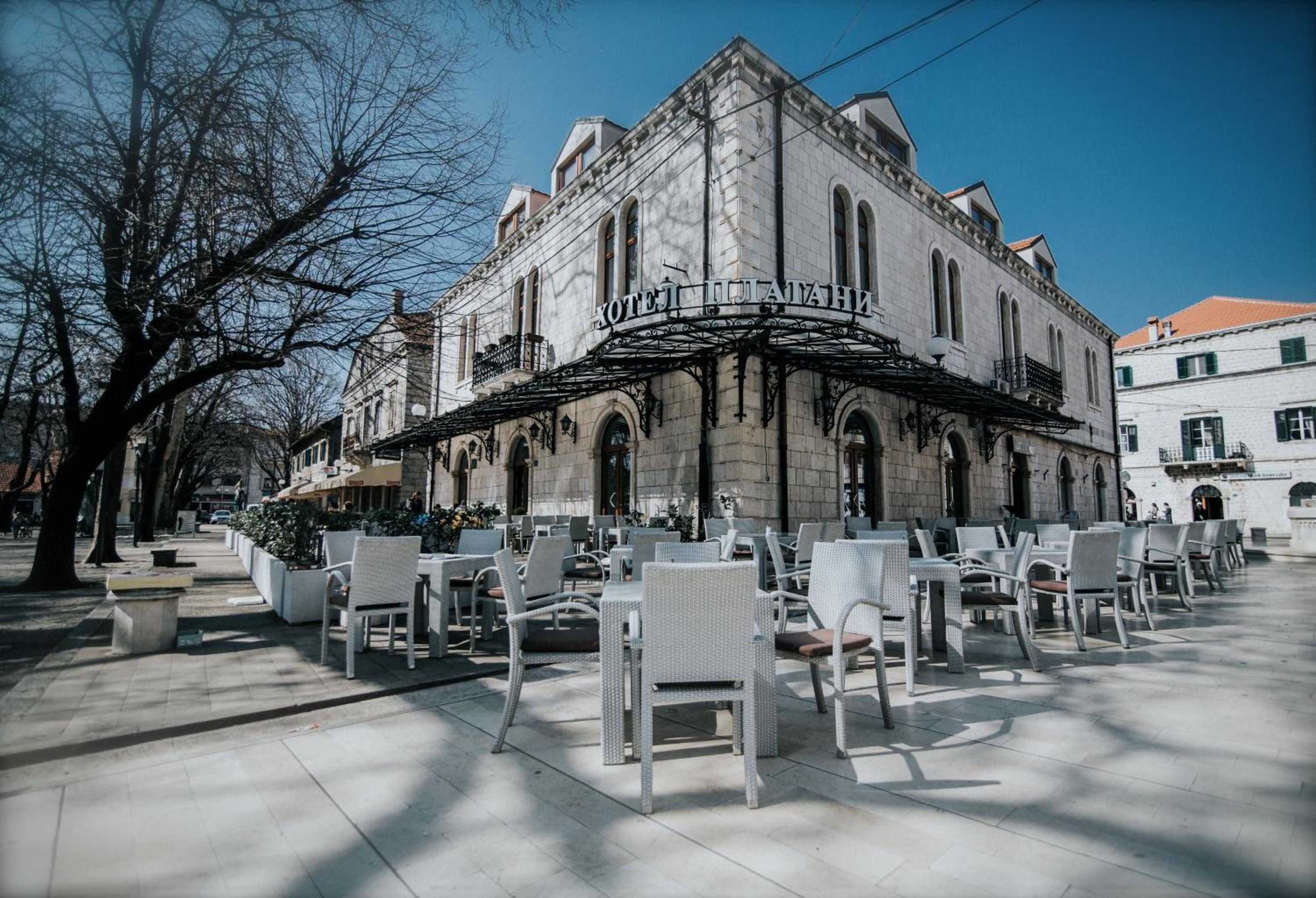 Ein historisches Gebäude mit einem Café-Bereich und Außenplätzen.