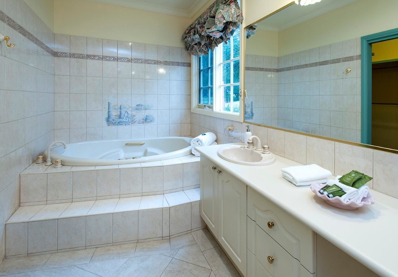 A modern bathroom with a freestanding bathtub, a vanity with a sink, and a large mirror.