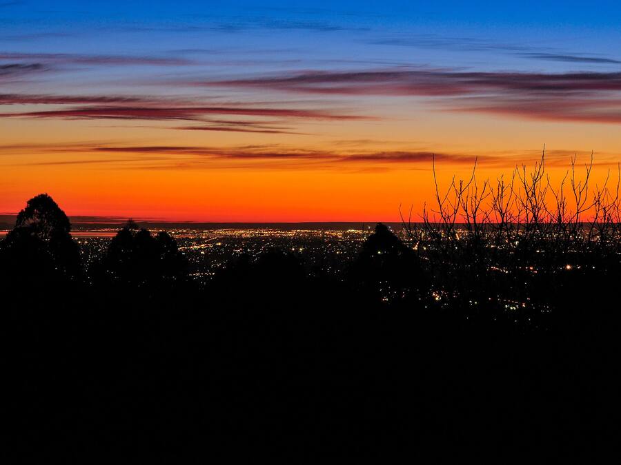 A cityscape at dusk with a sunset sky.