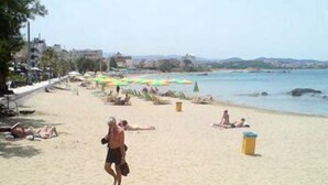 Une plage où l’on voit des gens se prélasser au soleil et se promener. On aperçoit des parasols et une poubelle.