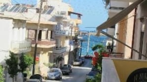 Une rue étroite, bordée de voitures garées et d’immeubles des deux côtés.