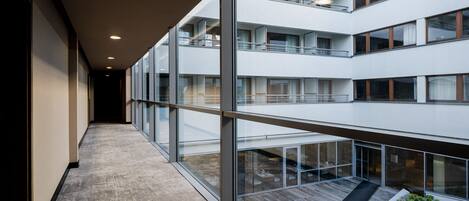 A modern building with multiple floors, large glass windows, and a central corridor.