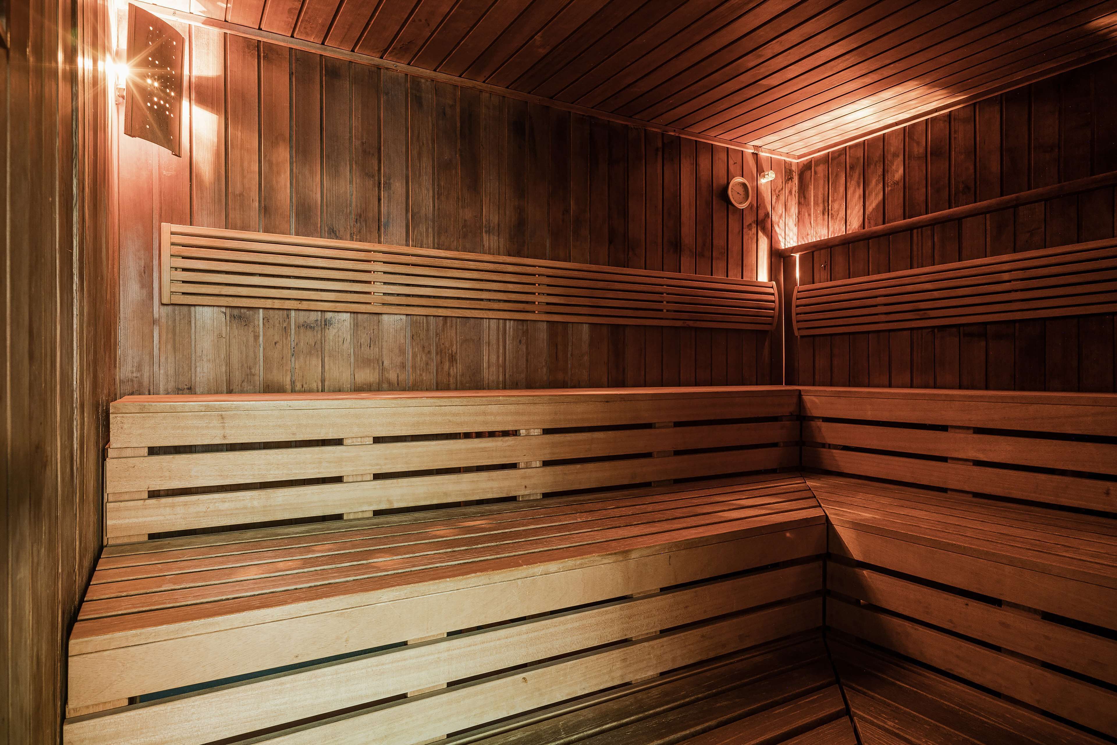Eine Sauna mit Holzbänken und schmalen Holzlatten.